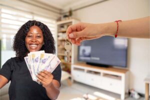 donna che esulta e mano con chiavi di casa