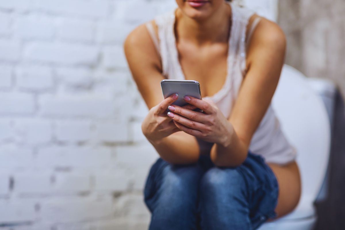 Donna in bagno con smartphone