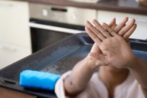 teglia sporca e donna che fa stop con le mani