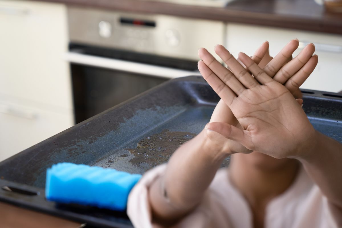 teglia sporca e donna che fa stop con le mani